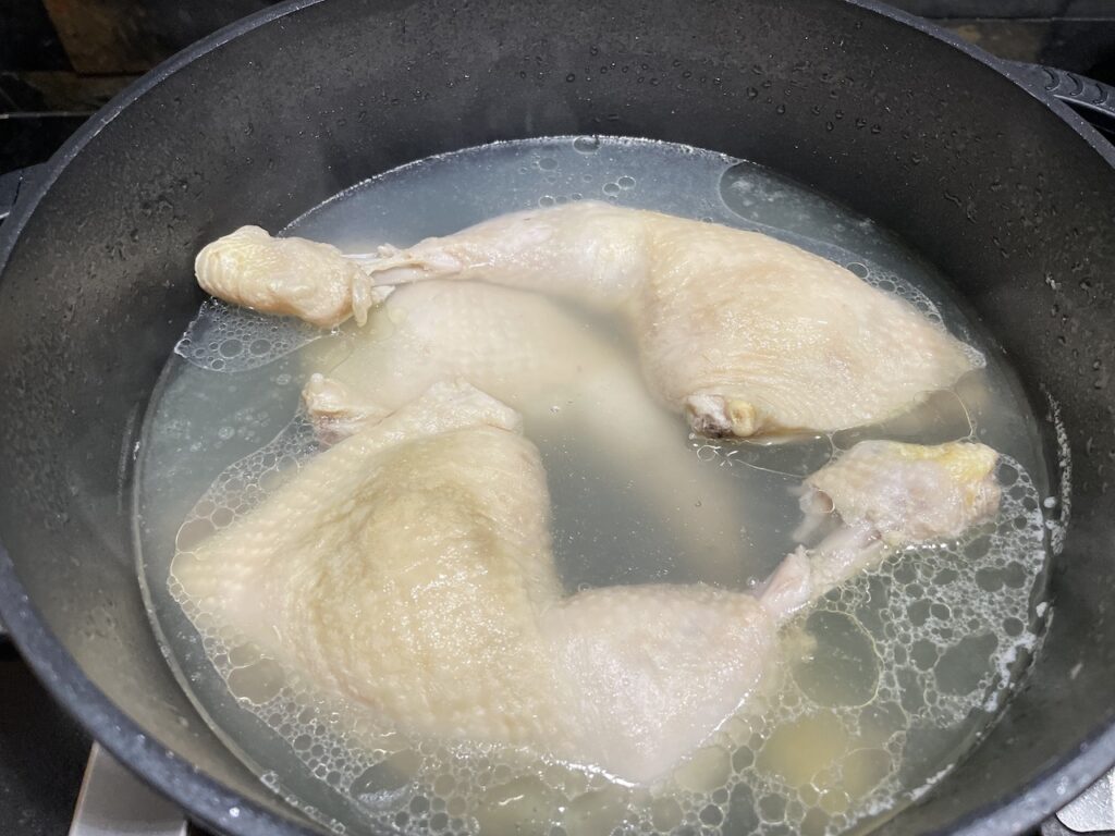 Boiling chicken in Pan for Chicken Macaroni Soup