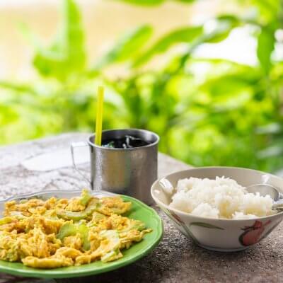 stir fried bitter gourd with egg and cooked rice on table,Filipino Food