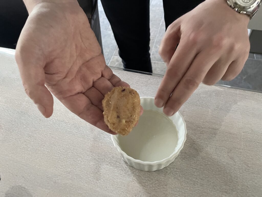 Shaped chicken nuggets being lightly sprayed with cooking oil using a spray bottle or hands when you don't have a spray.