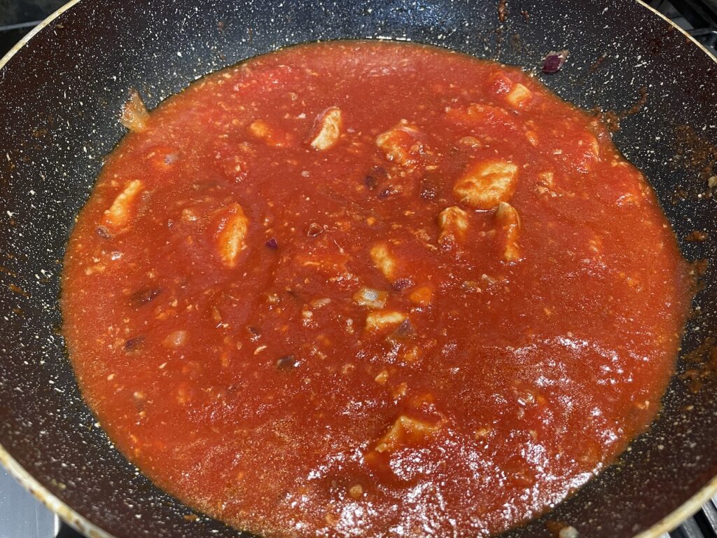 Adding tomato sauce to Pork Caldereta